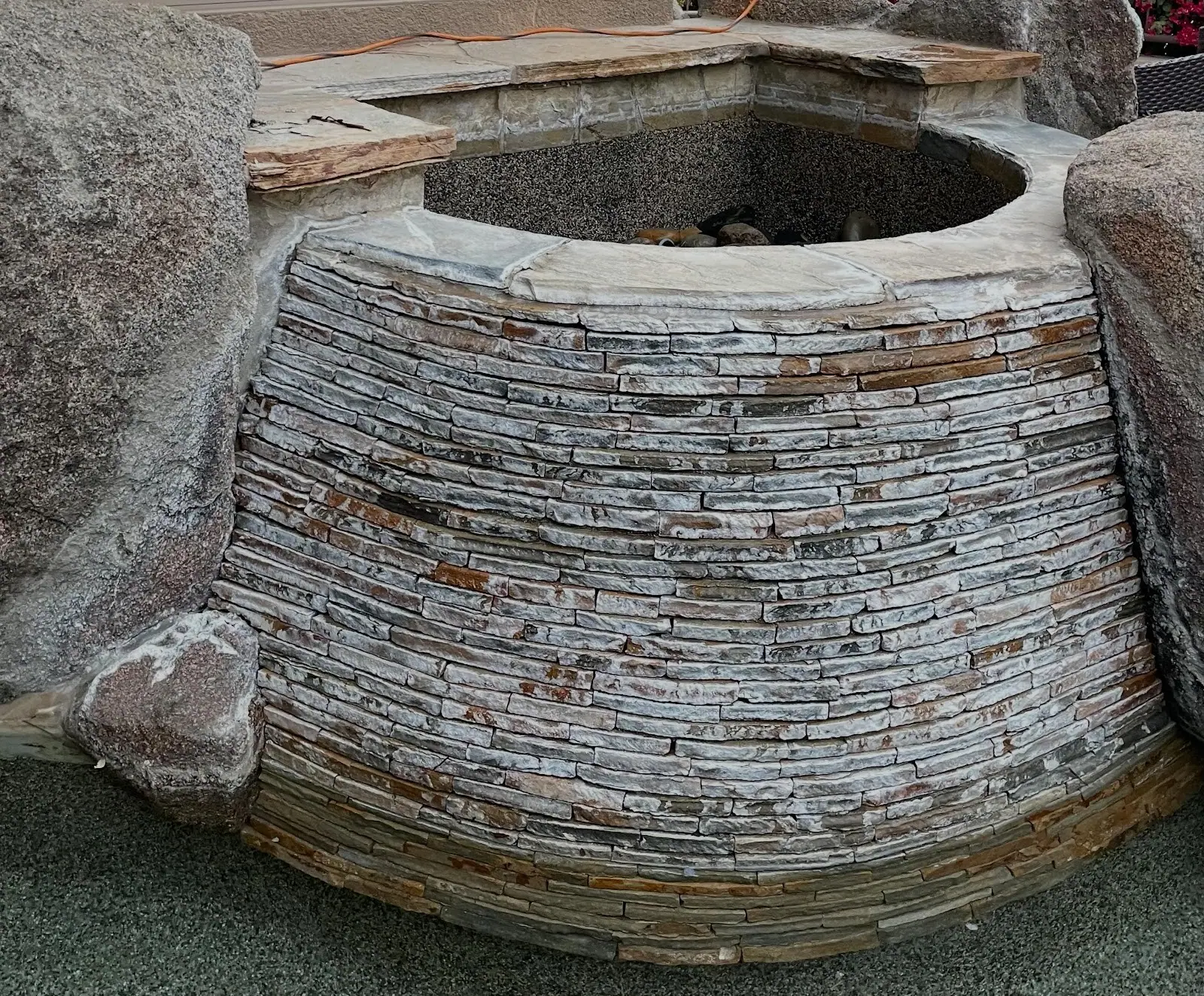 Before: Stacked stone water feature covered in white calcium buildup